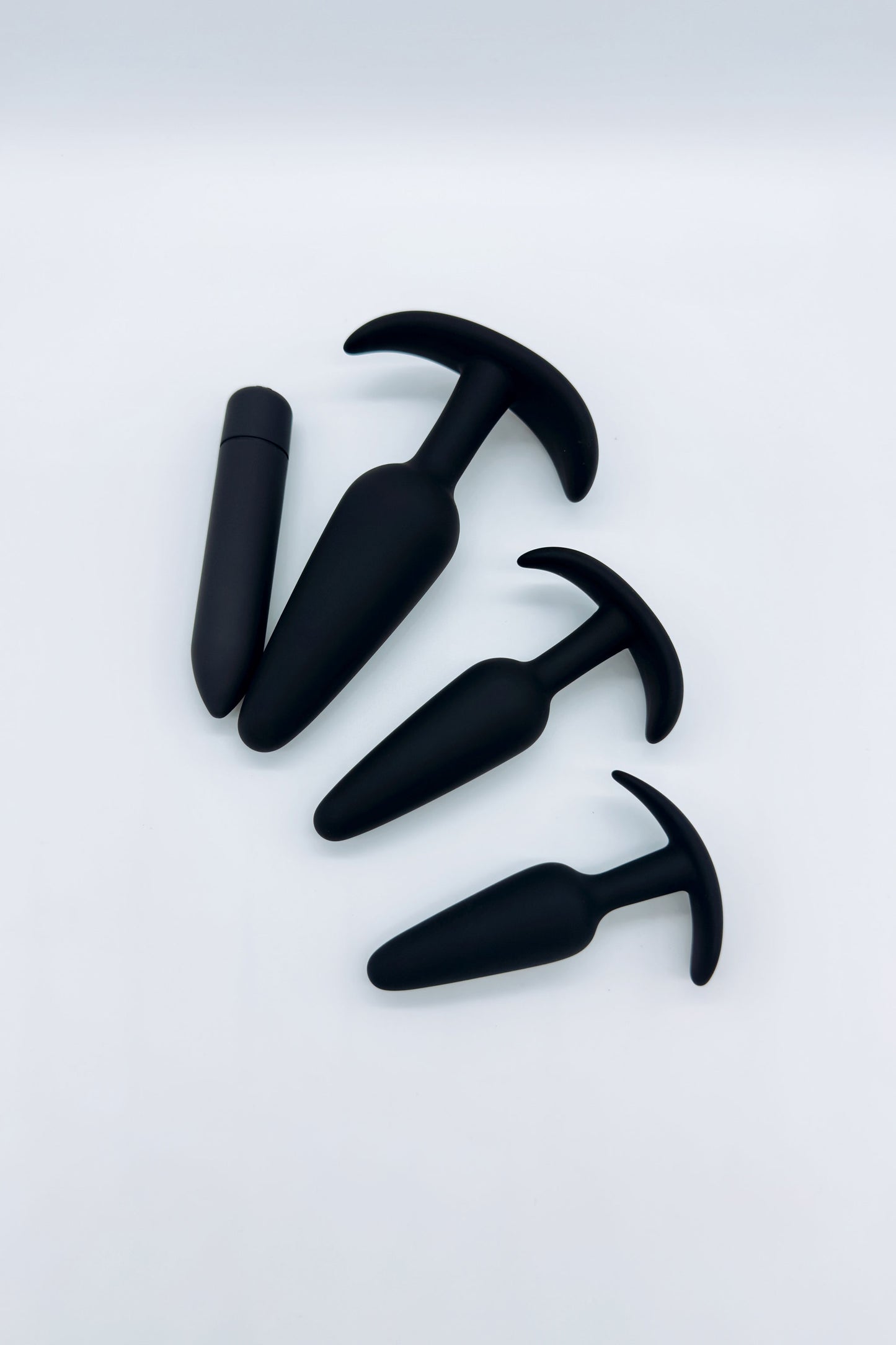 Three tapered anal plugs in small, medium, and large sizes and mini bullet