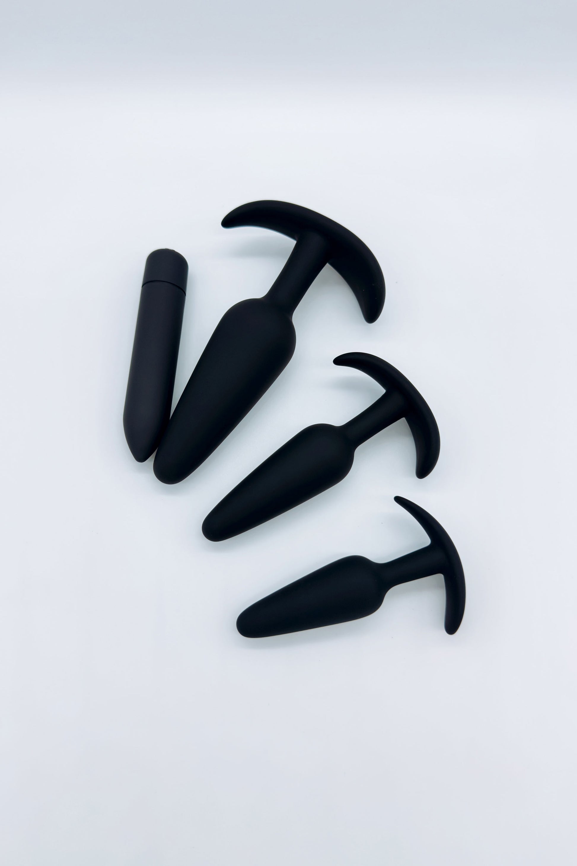 Three tapered anal plugs in small, medium, and large sizes and mini bullet