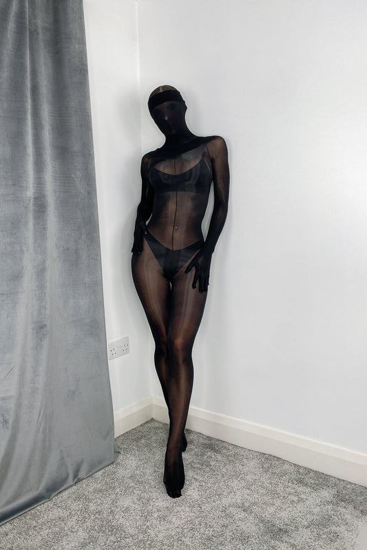 Close-up of black oil sheen on nylon bodystocking, gloves, and toe socks, high-gloss texture